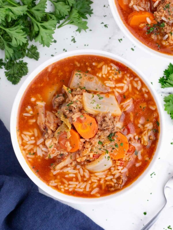 An overhead shot of cabbage roll soup in a white bowl.