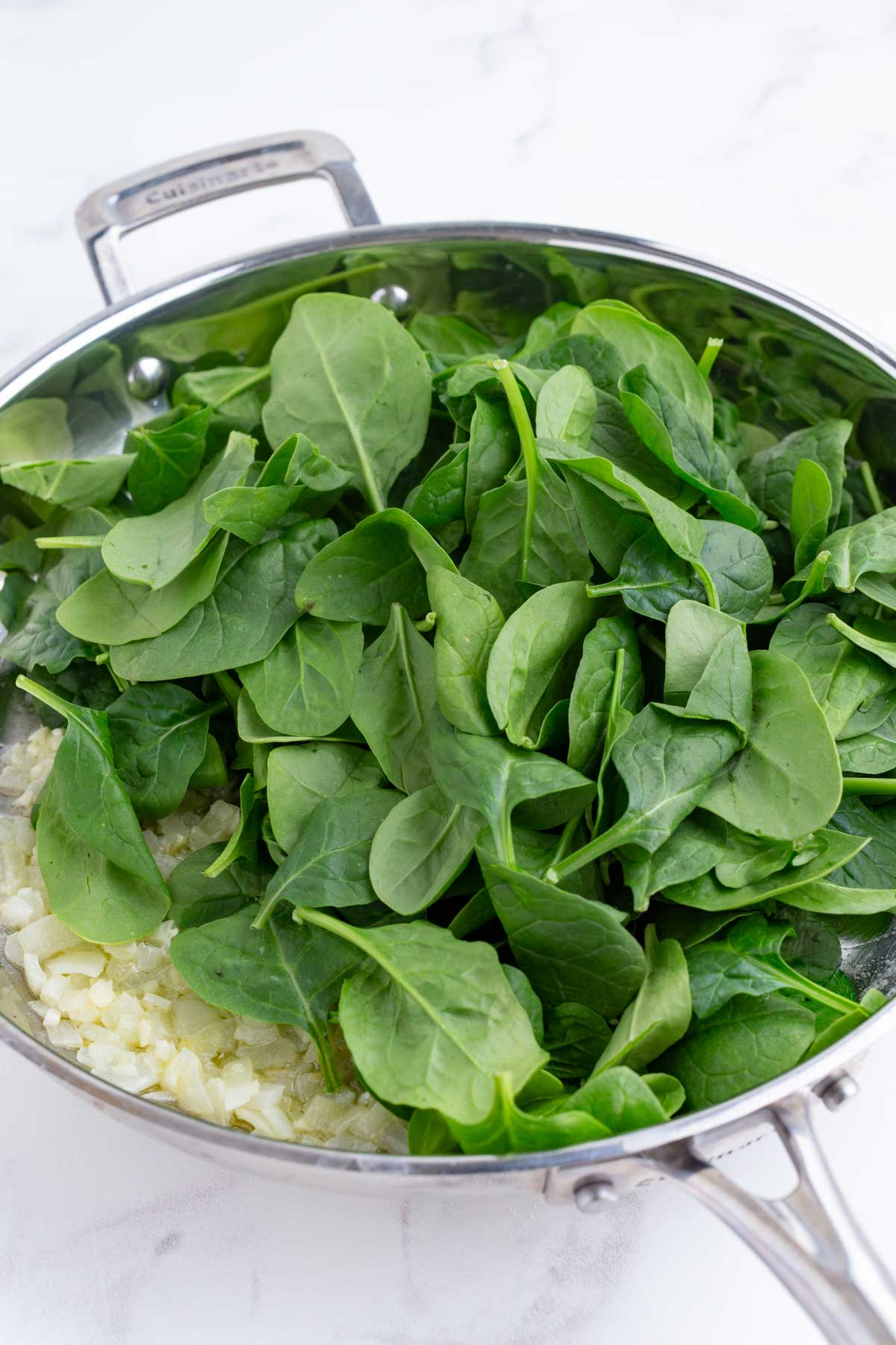 Spinach is added to the skillet.