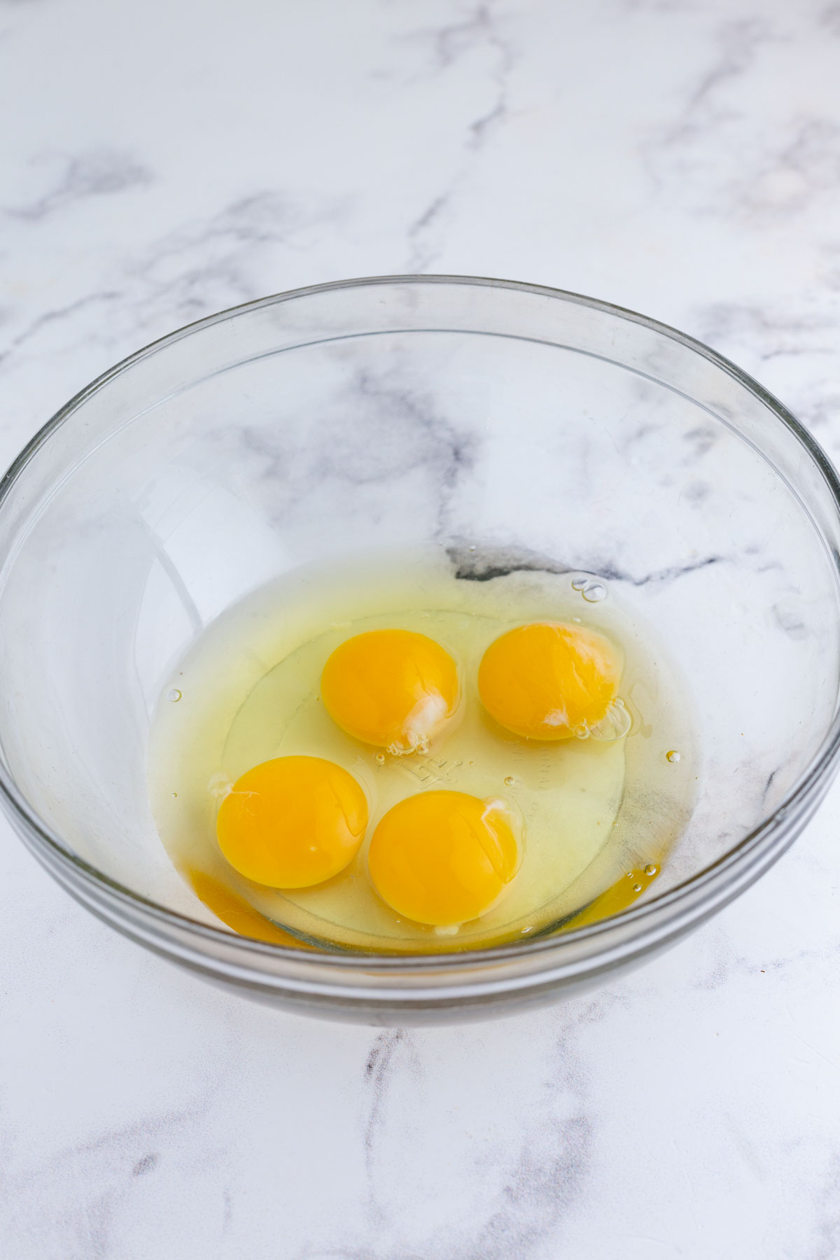 Eggs are cracked into a bowl.