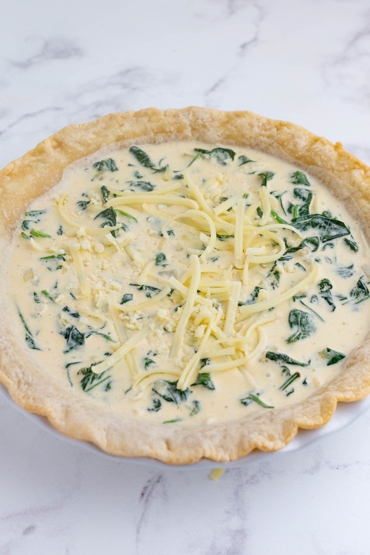 Cheese is sprinkled on to of the quiche.