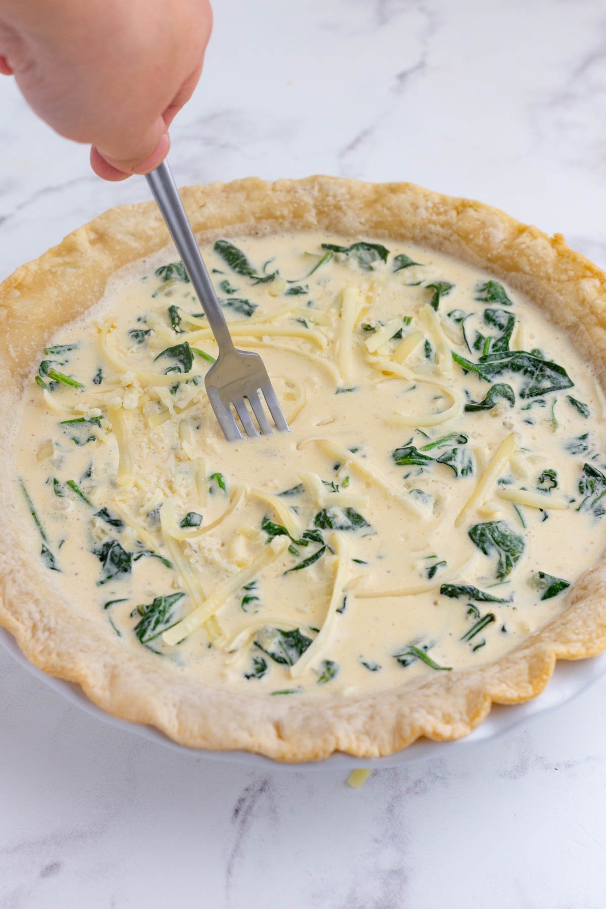 A fork stirs the ingredients before baking.