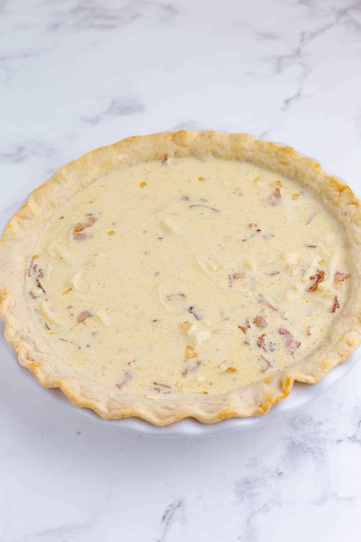 A raw quiche is ready to bake.