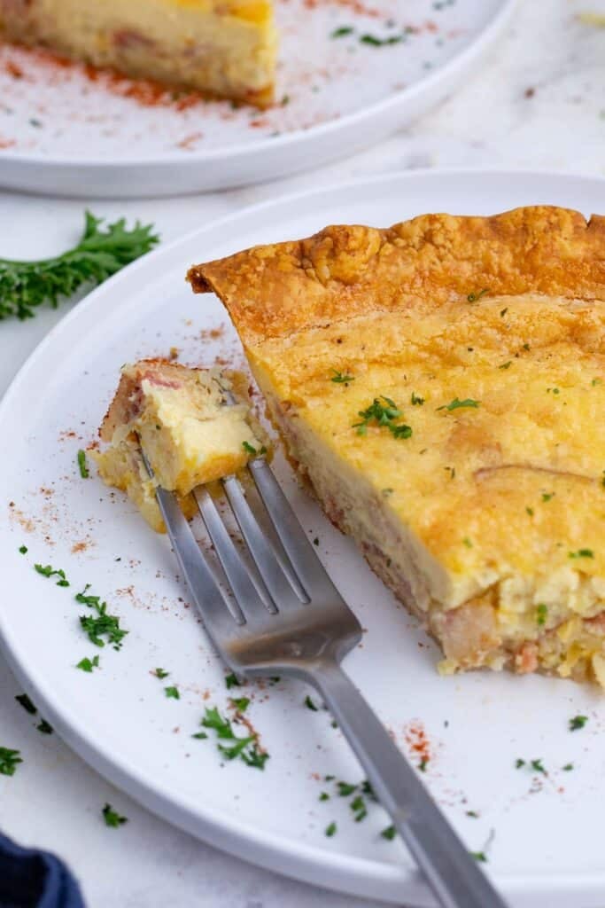 A whole quiche lorraine in a pie dish with golden top and flaky crust for Easy Quiche Lorraine