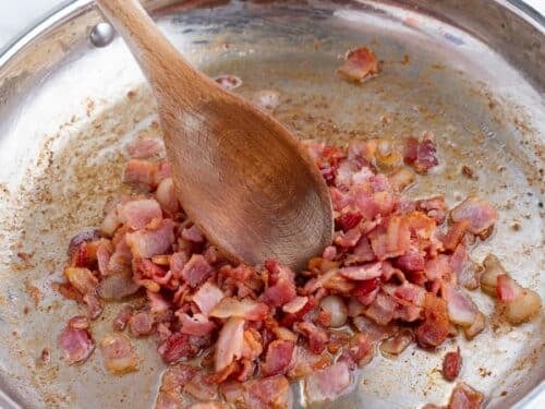 Bacon is cooked in a skillet.