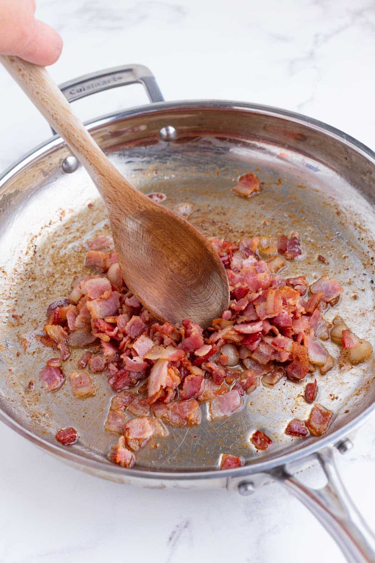 Bacon is cooked in a skillet.