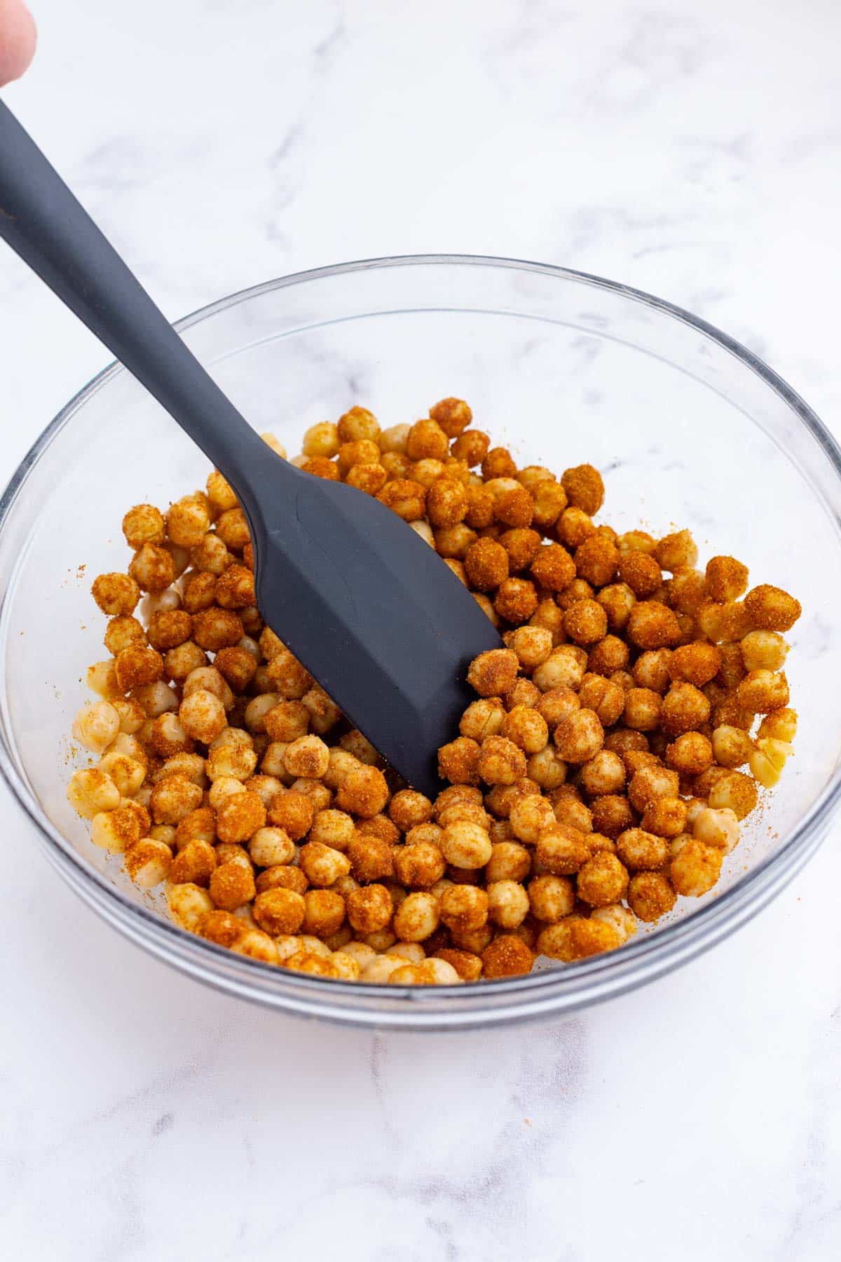 Chickpeas are stirred to mix with the seasonings.