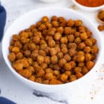 A white bowl of chickpeas roasted in the oven is a healthy snack.