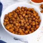 A white bowl of chickpeas roasted in the oven is a healthy snack.