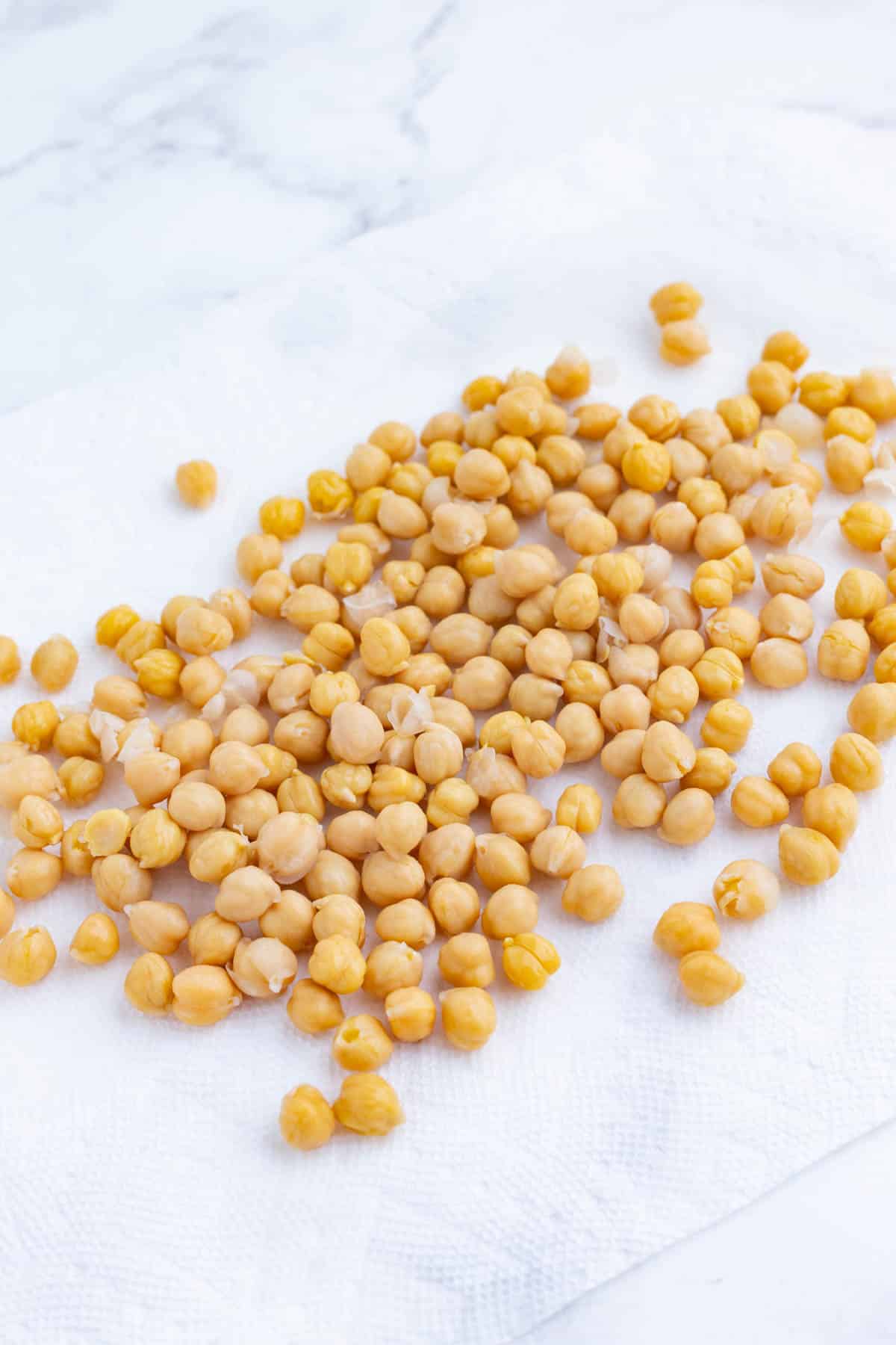 Chickpeas are dried on a paper towel.