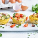 Three different flavored egg muffins are served on a white plate.