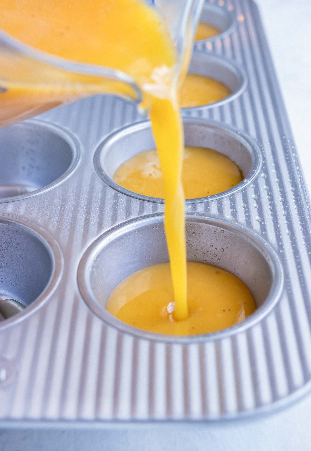 The egg mixture is poured into the non-stick muffin pan.