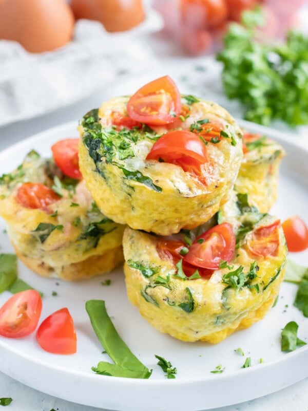 A pile of four egg muffins are served on a white plate.