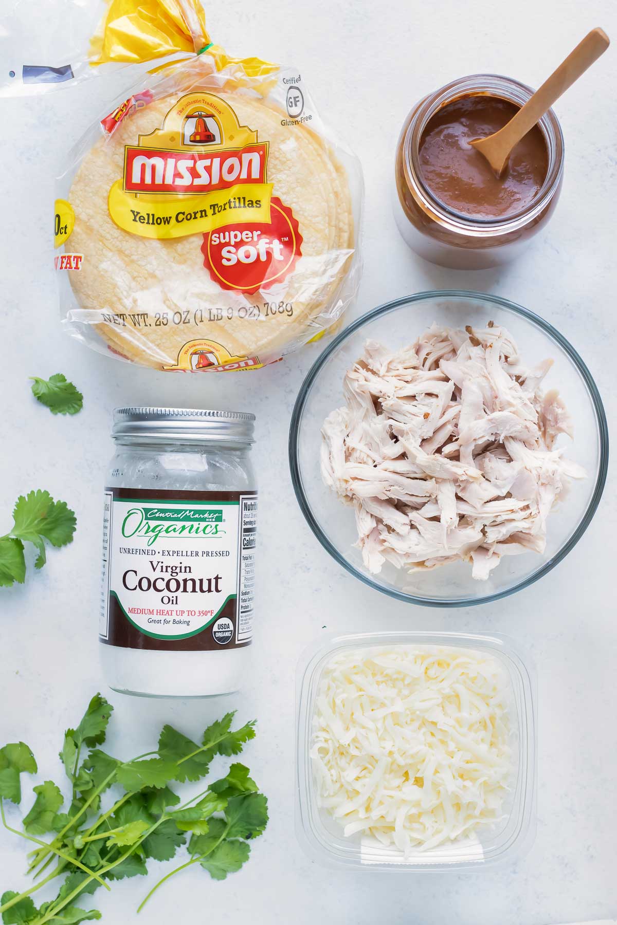 Coconut oil, chicken, corn tortillas, mole sauce, cheese, and cilantro are the ingredients for this recipe.