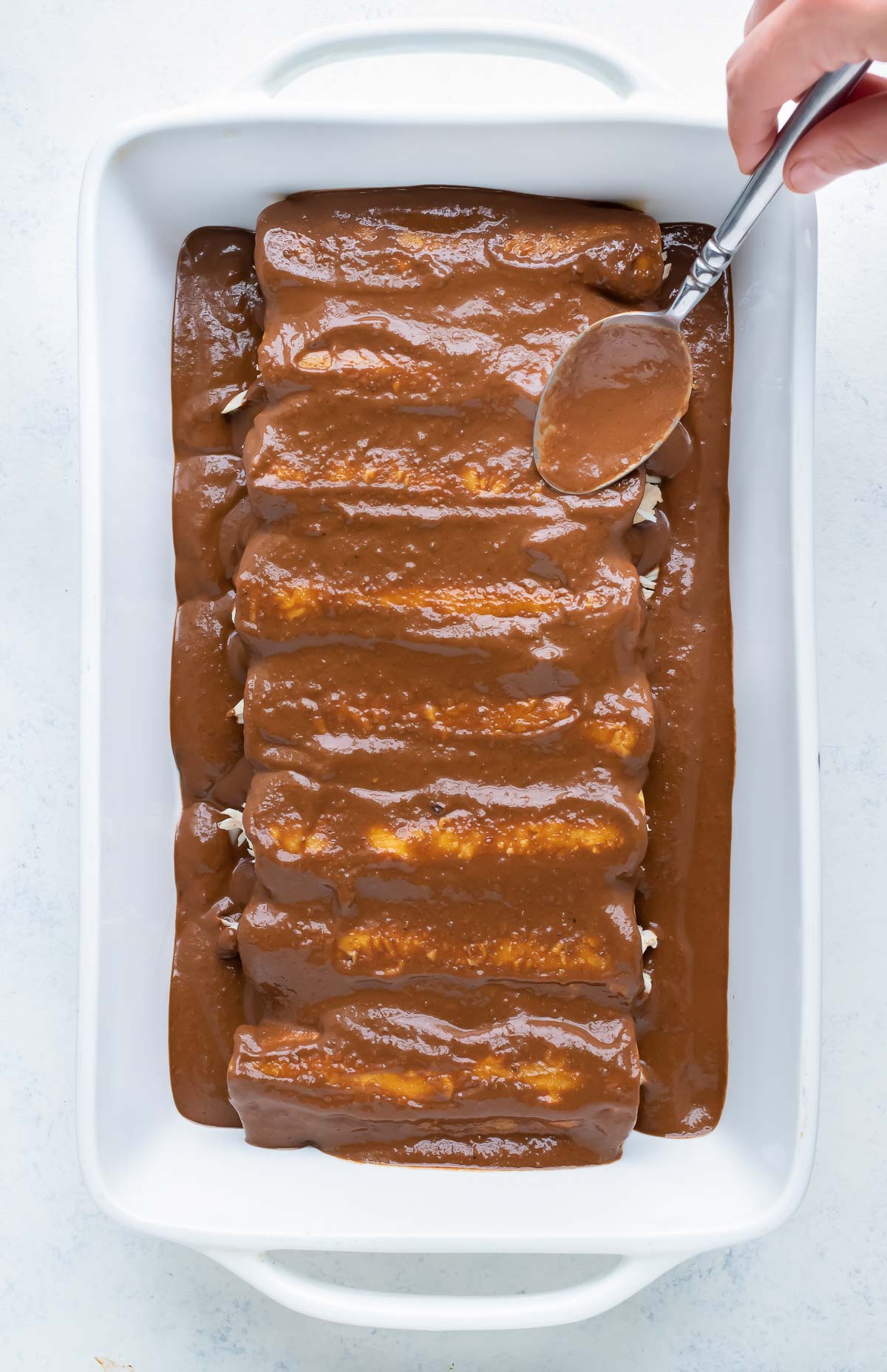Authentic mole sauce is used to cover the enchiladas.