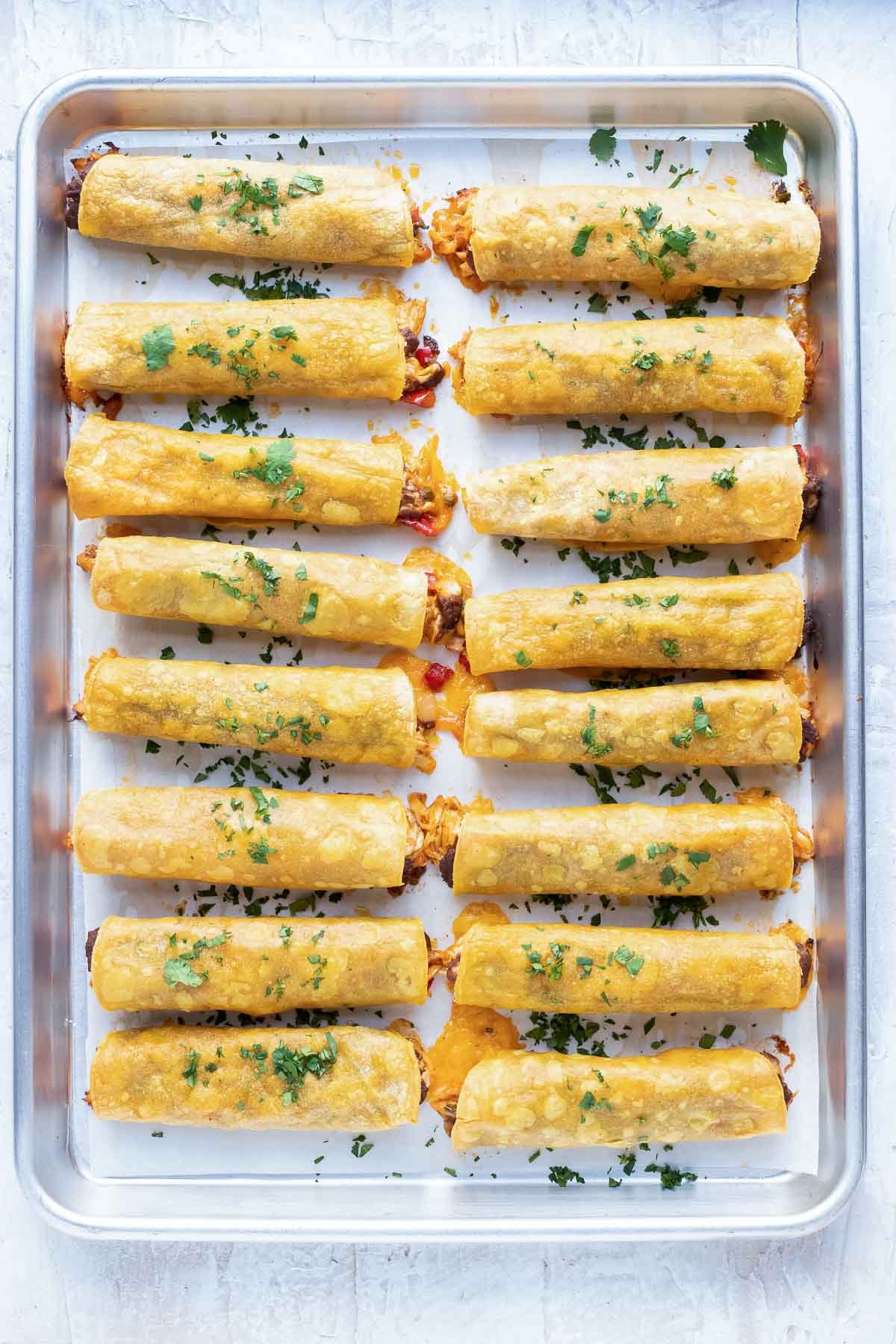 Baked taquitos topped with cilantro.