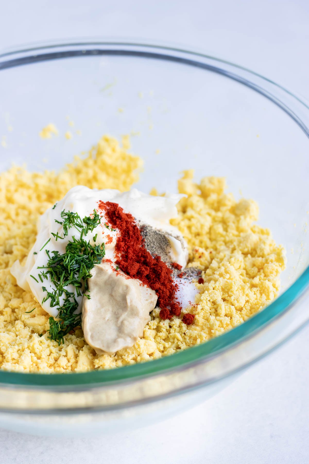 Filling ingredients are added to the mashed yolks.