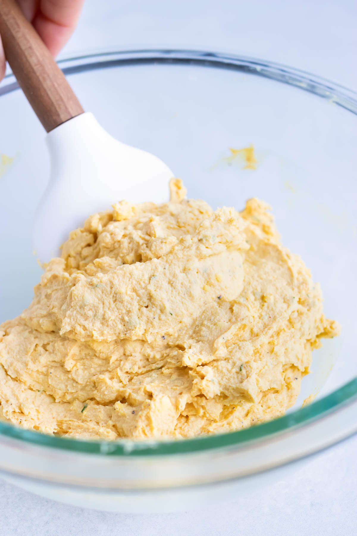 A spatula stirs the yolk mixture.