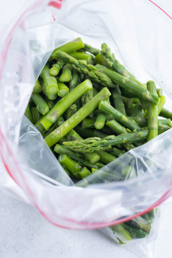 Frozen cut up asparagus in a freezer bag opened at the top.