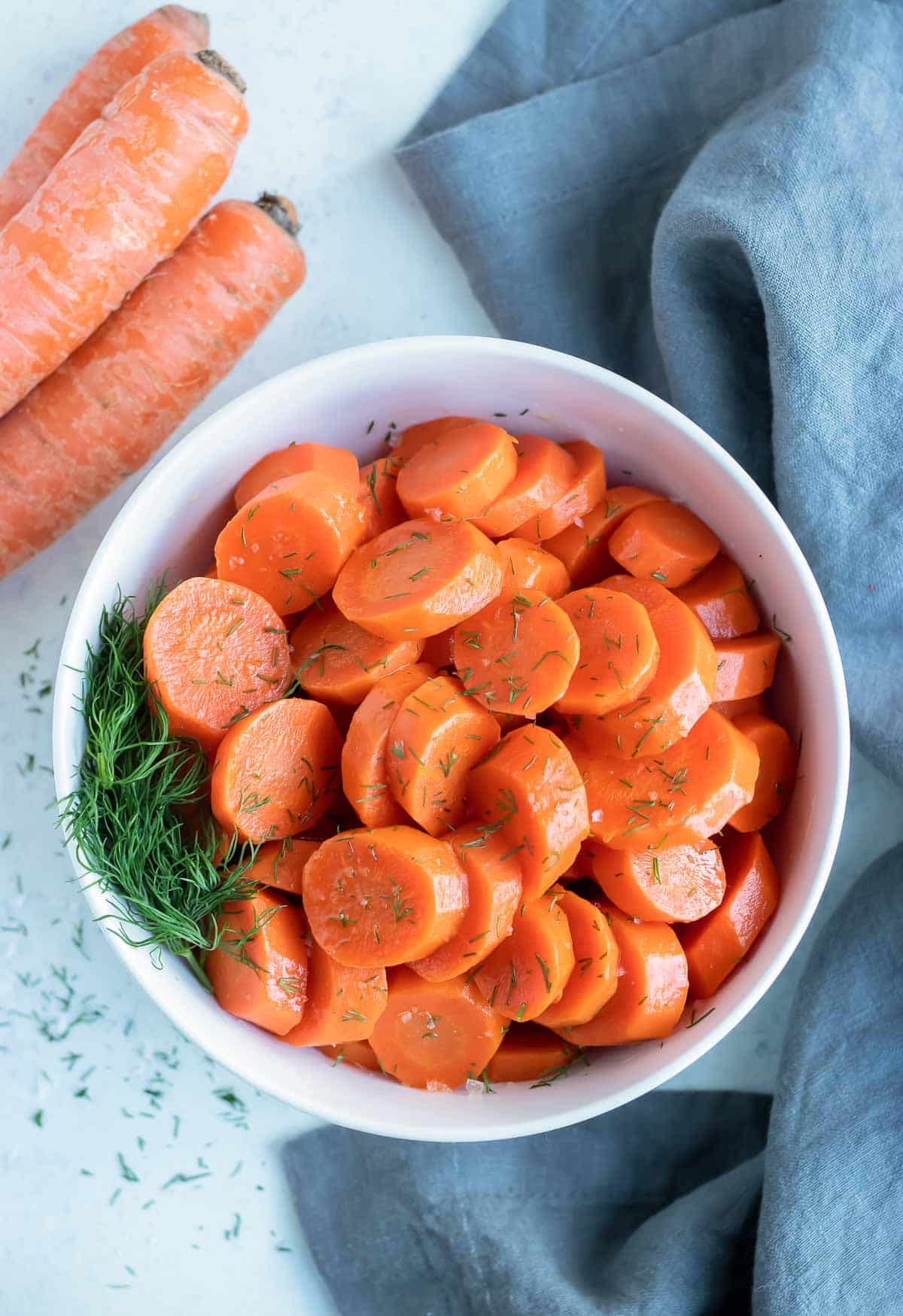 Boiled carrots are served in a bowl for a side.