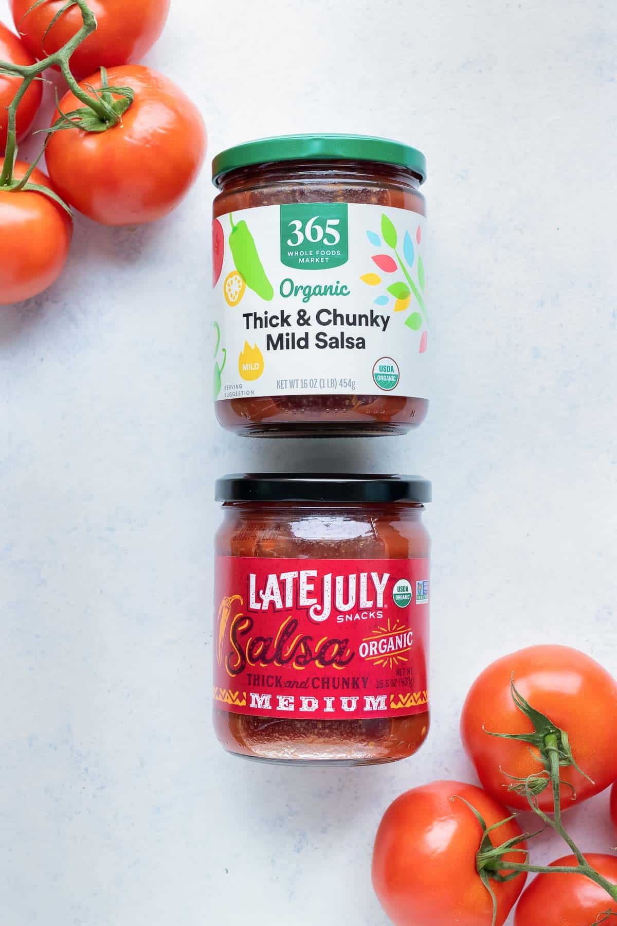 Two different types of chunky salsa are shown on the counter.