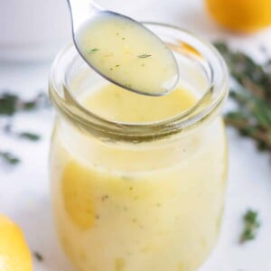 Easy homemade vinaigrette is served with a metal spoon.