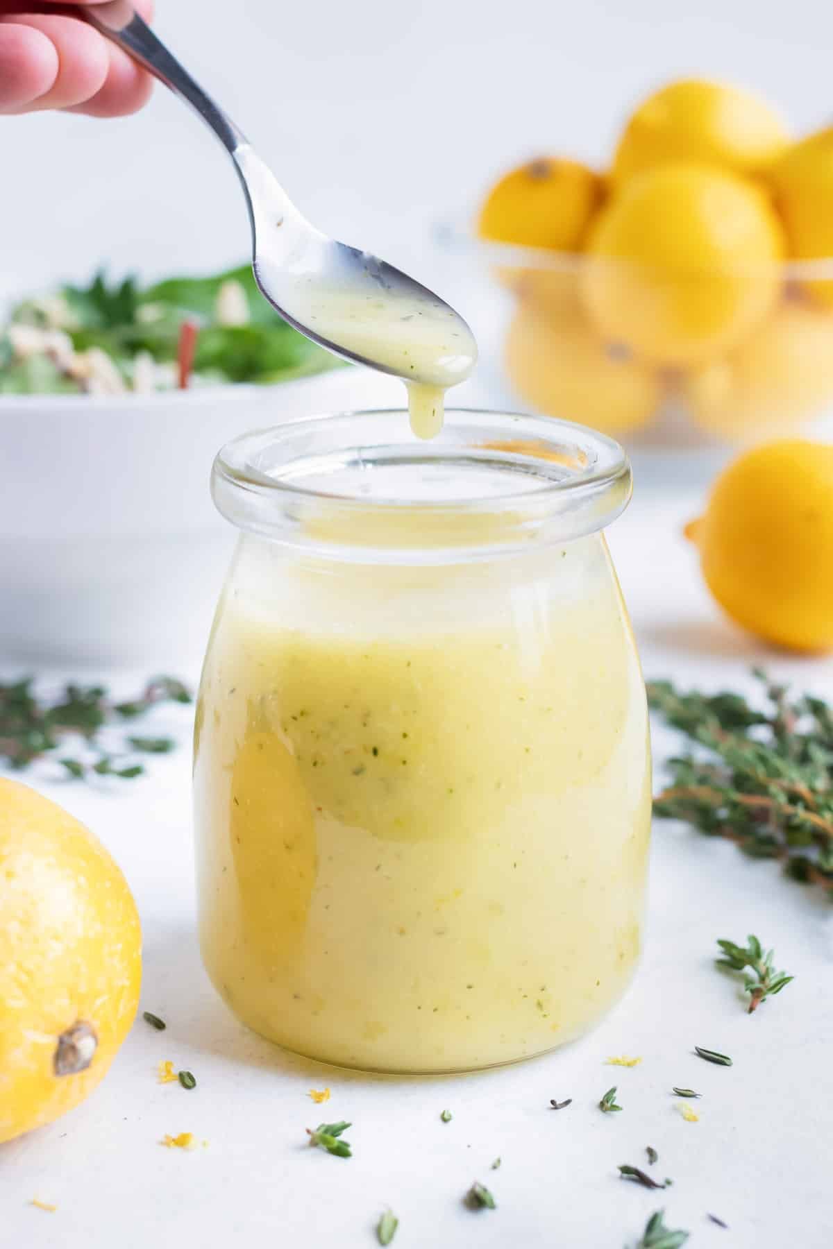 Lemon dressing is served with a spoon from a jar.