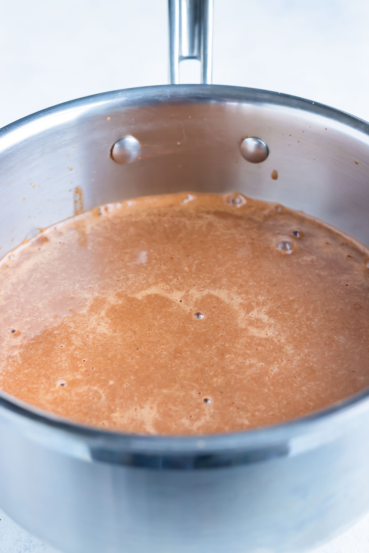 The blended mole sauce is added back into the saucepan to simmer and thicken.