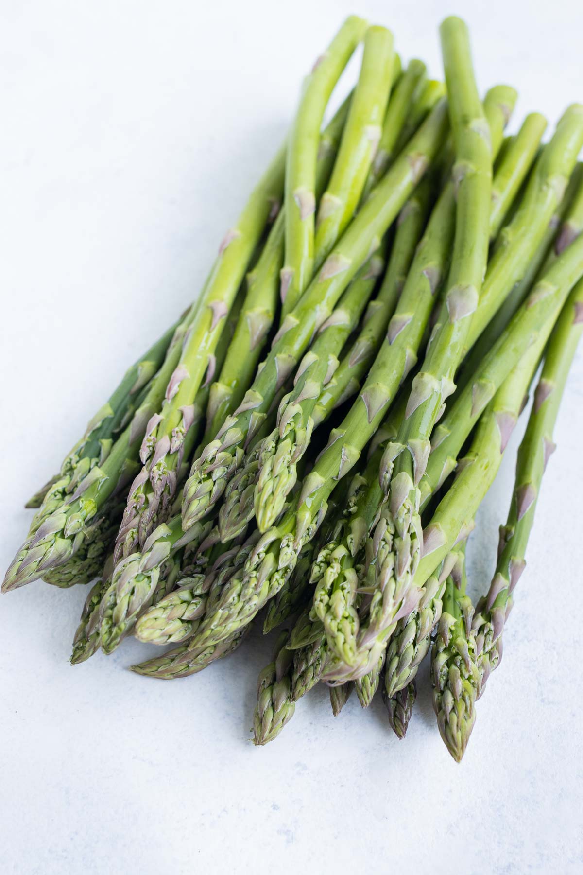 Asparagus lined up on a countertop.