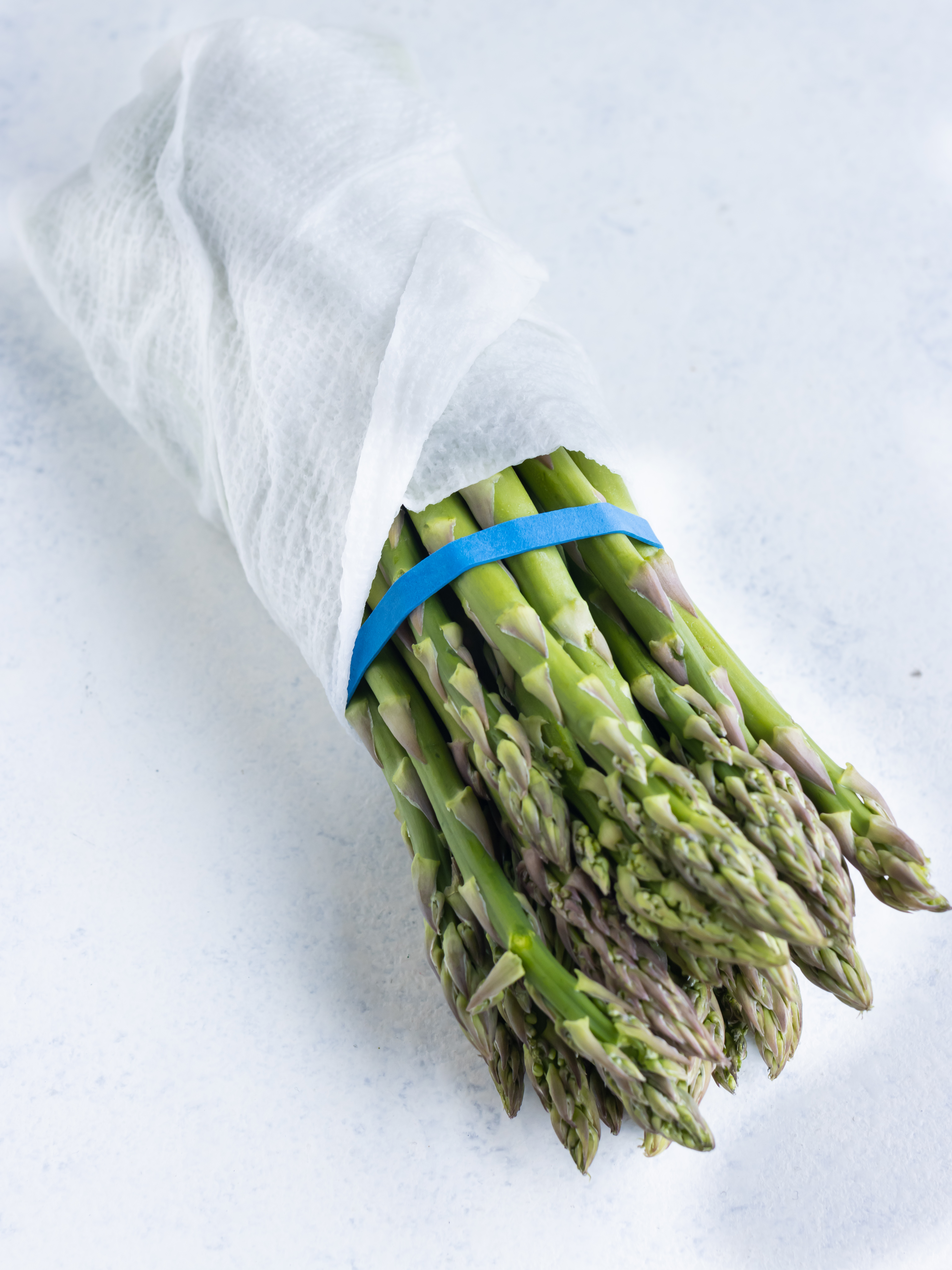 One bunch of asparagus wrapped in a damp paper towel.