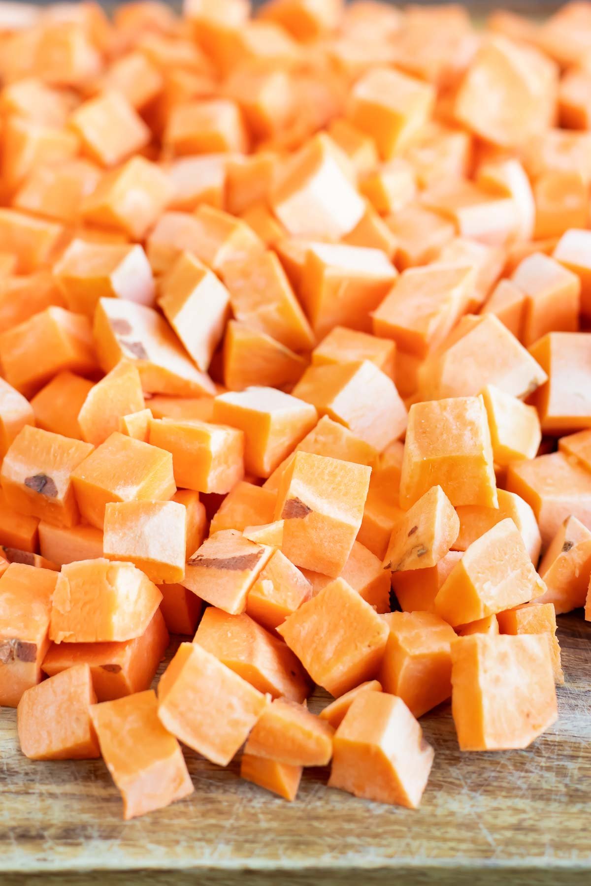 Sweet potatoes are peeled and chopped into cubes.