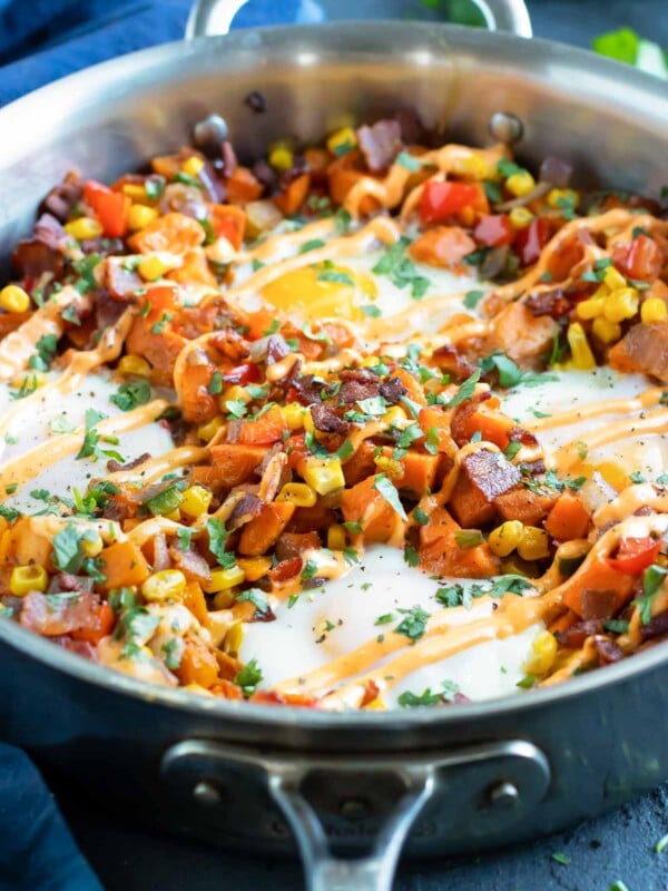 A skillet full of a sweet potato hash recipe with eggs.