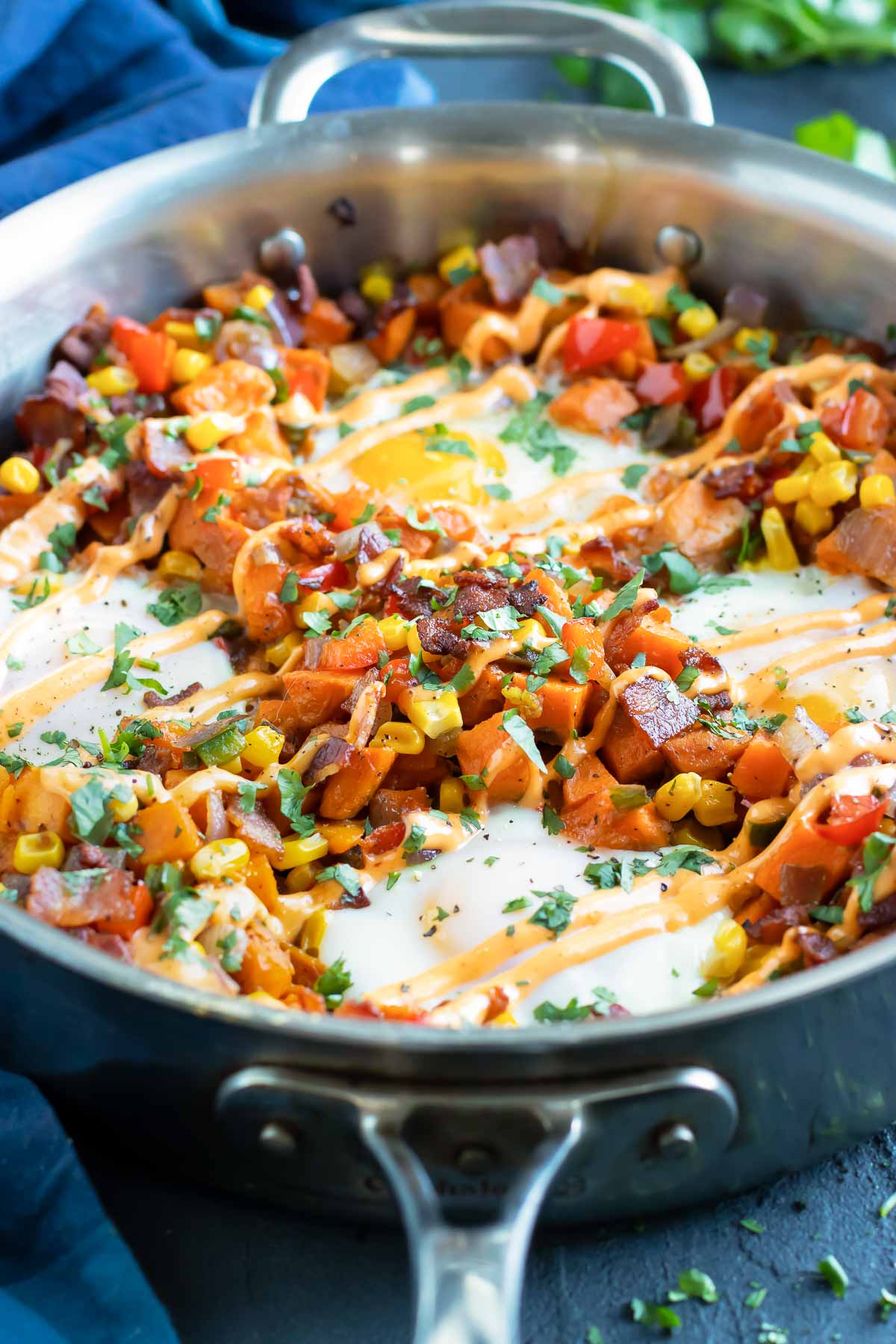 A skillet full of a sweet potato hash recipe with eggs.