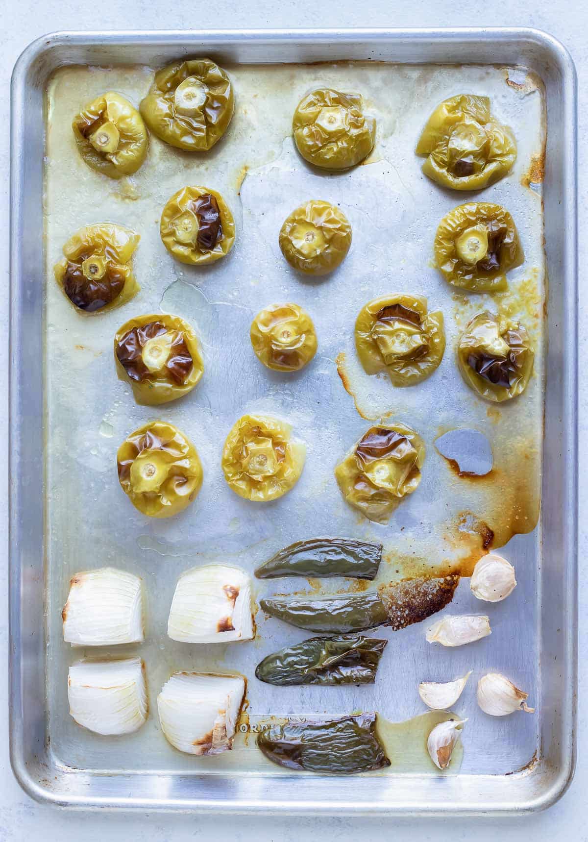 Tomatillos, onion, jalapeño peppers, and garlic are roasted in the oven.
