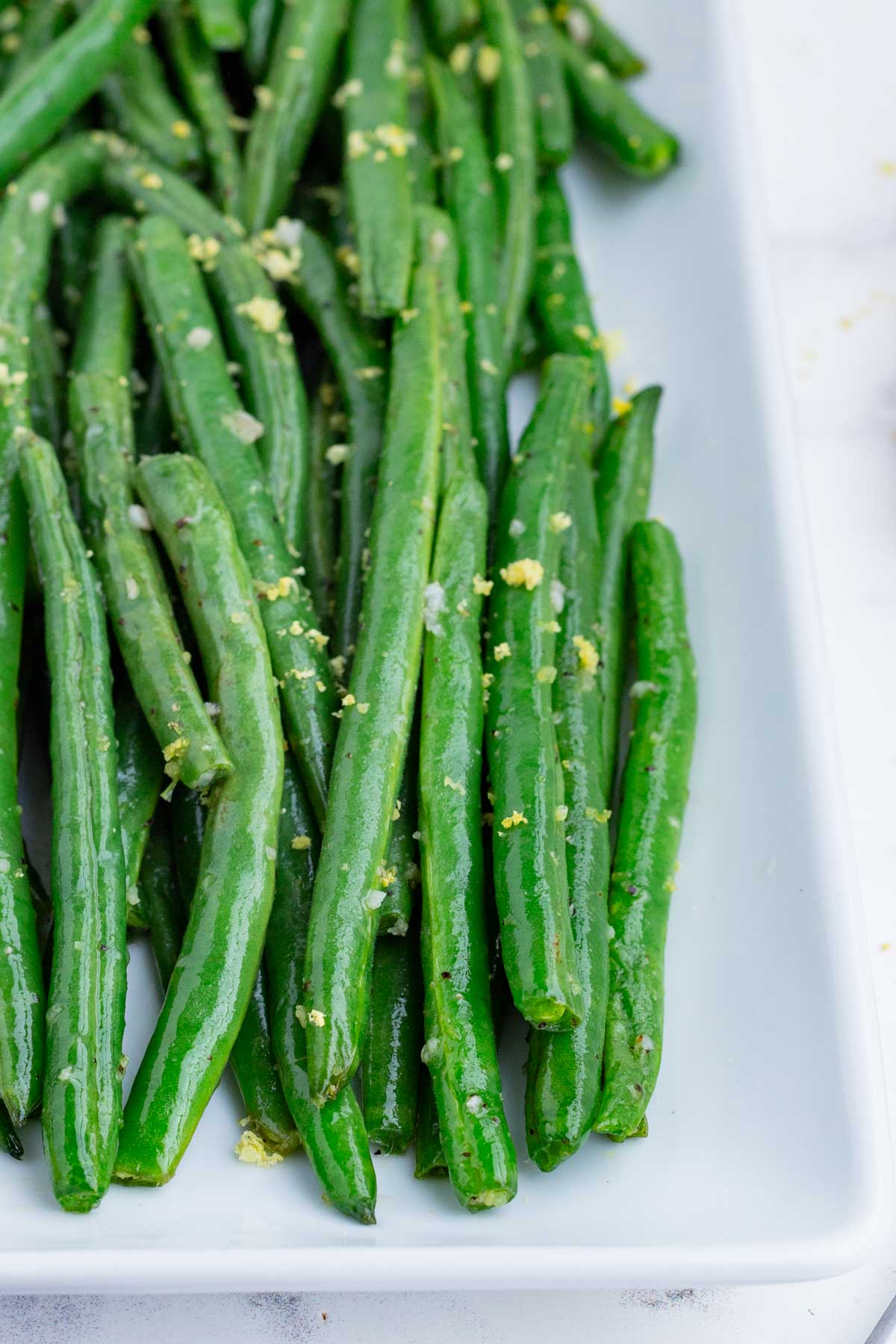 A close up of air fryer green beans on a white plate.