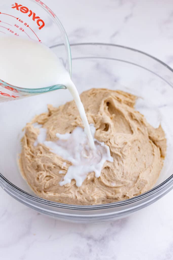 Milk is poured into the batter and mixed.