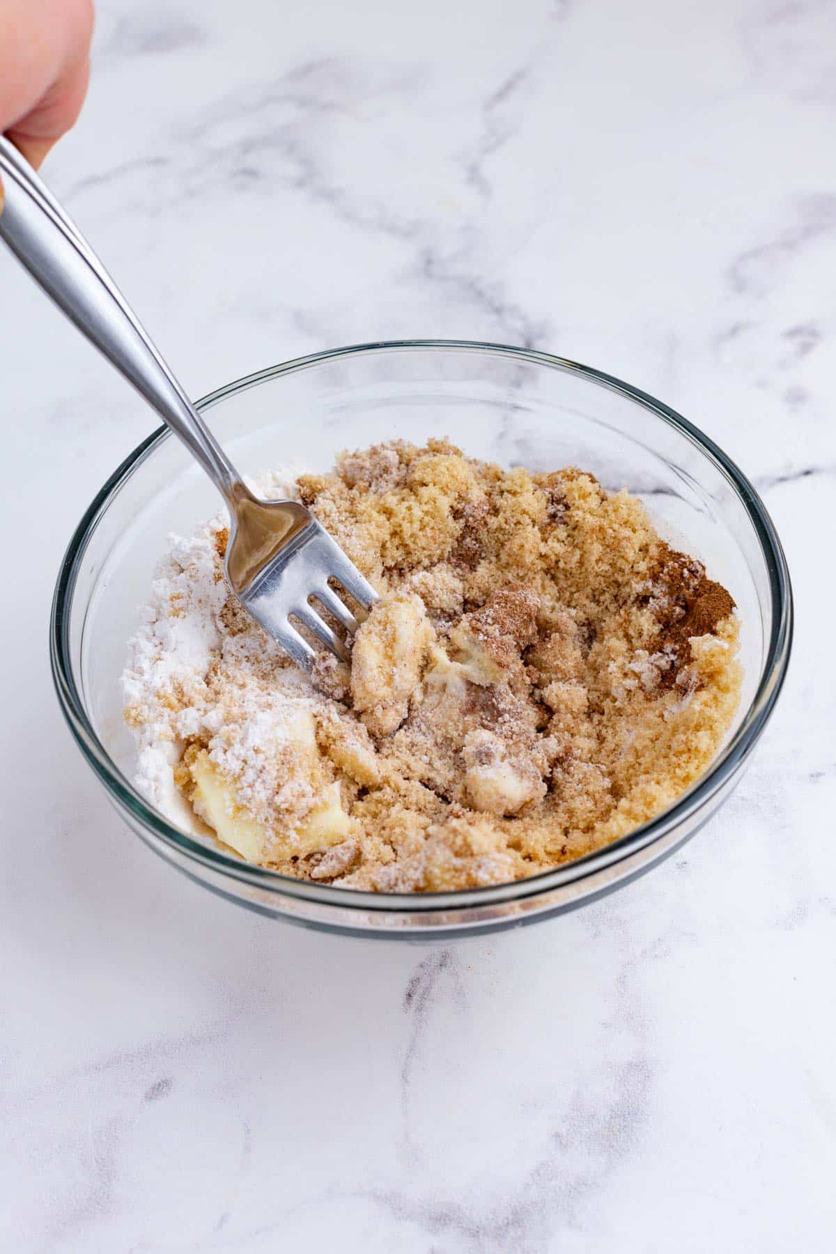 A fork cuts the butter into the crumb topping.