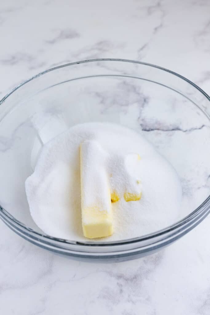 Butter and sugar are added to a bowl.