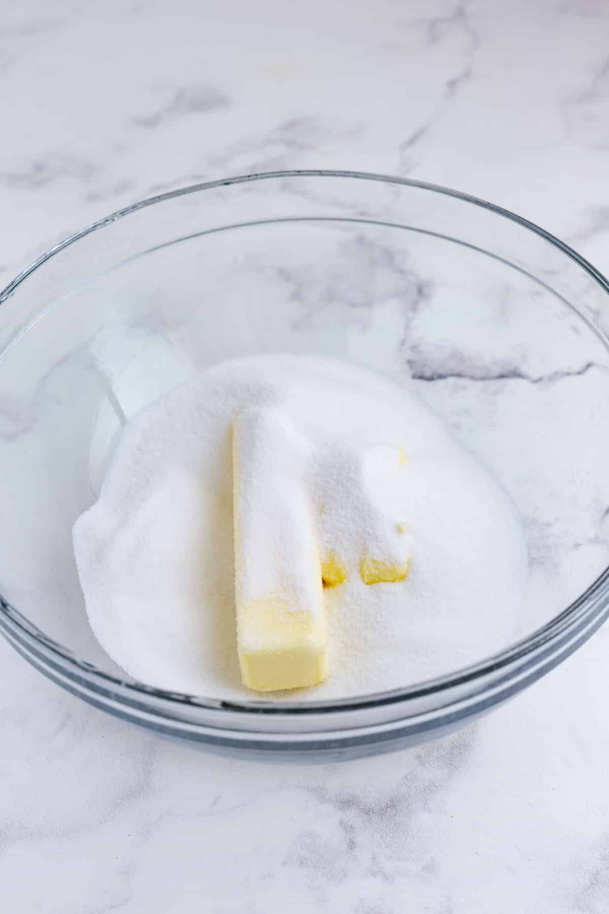 Butter and sugar are added to a bowl.