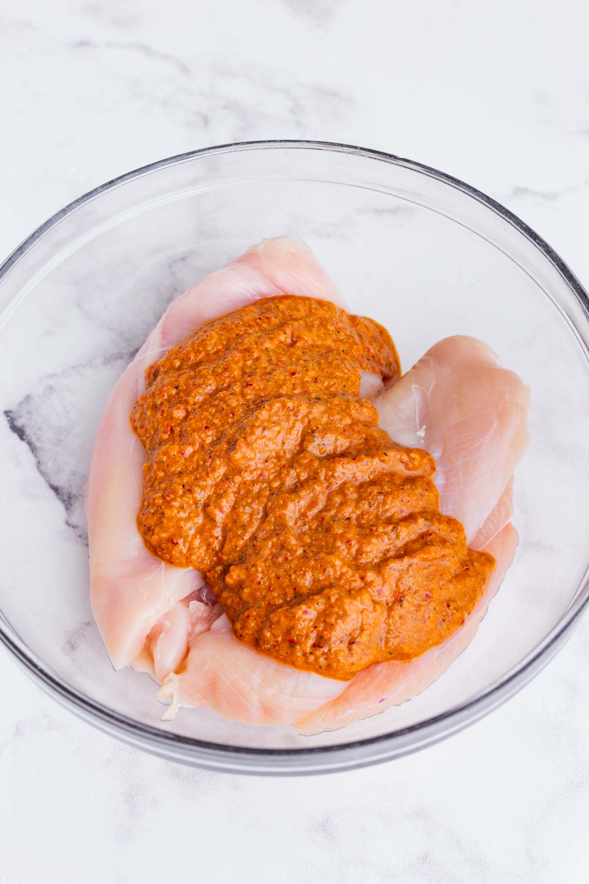Marinade is added to chicken breasts.