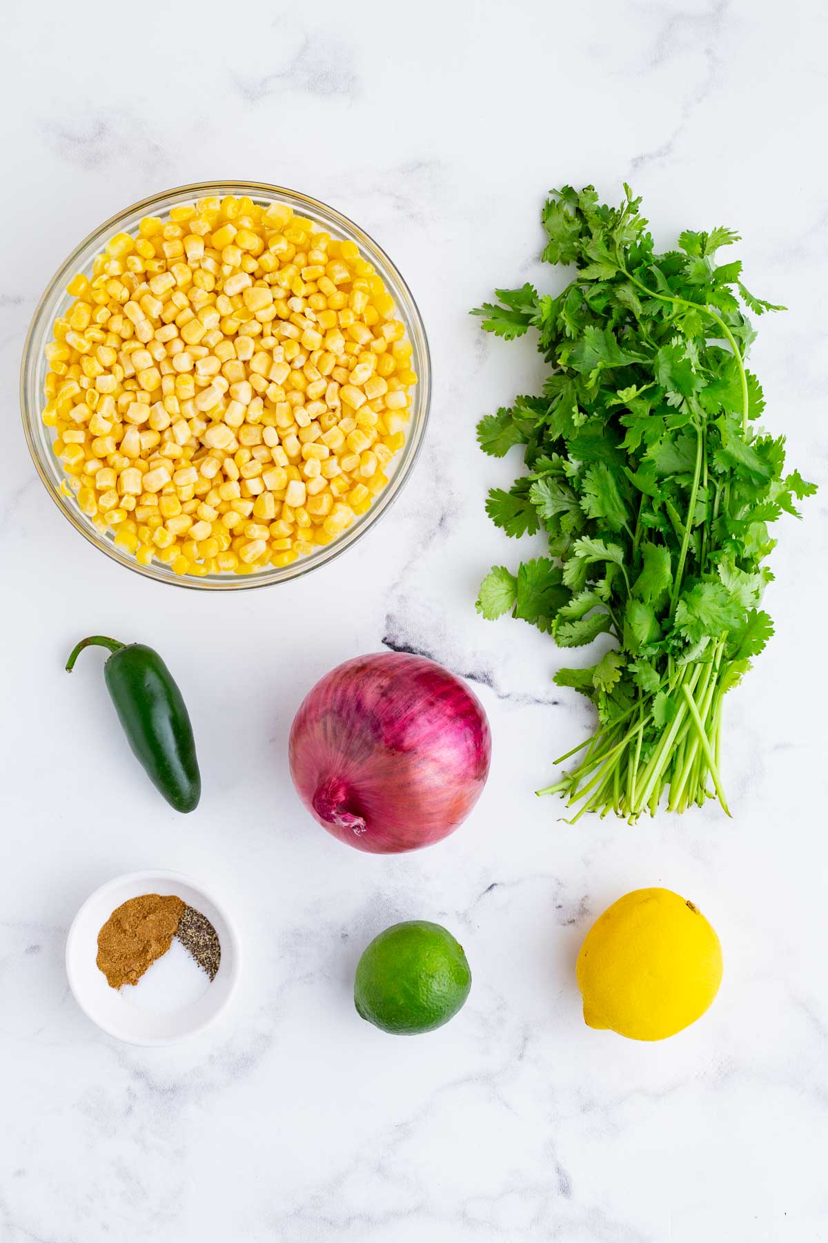 Corn, cilantro, onion, lemon, lime, and seasonings are the ingredients for this dish.