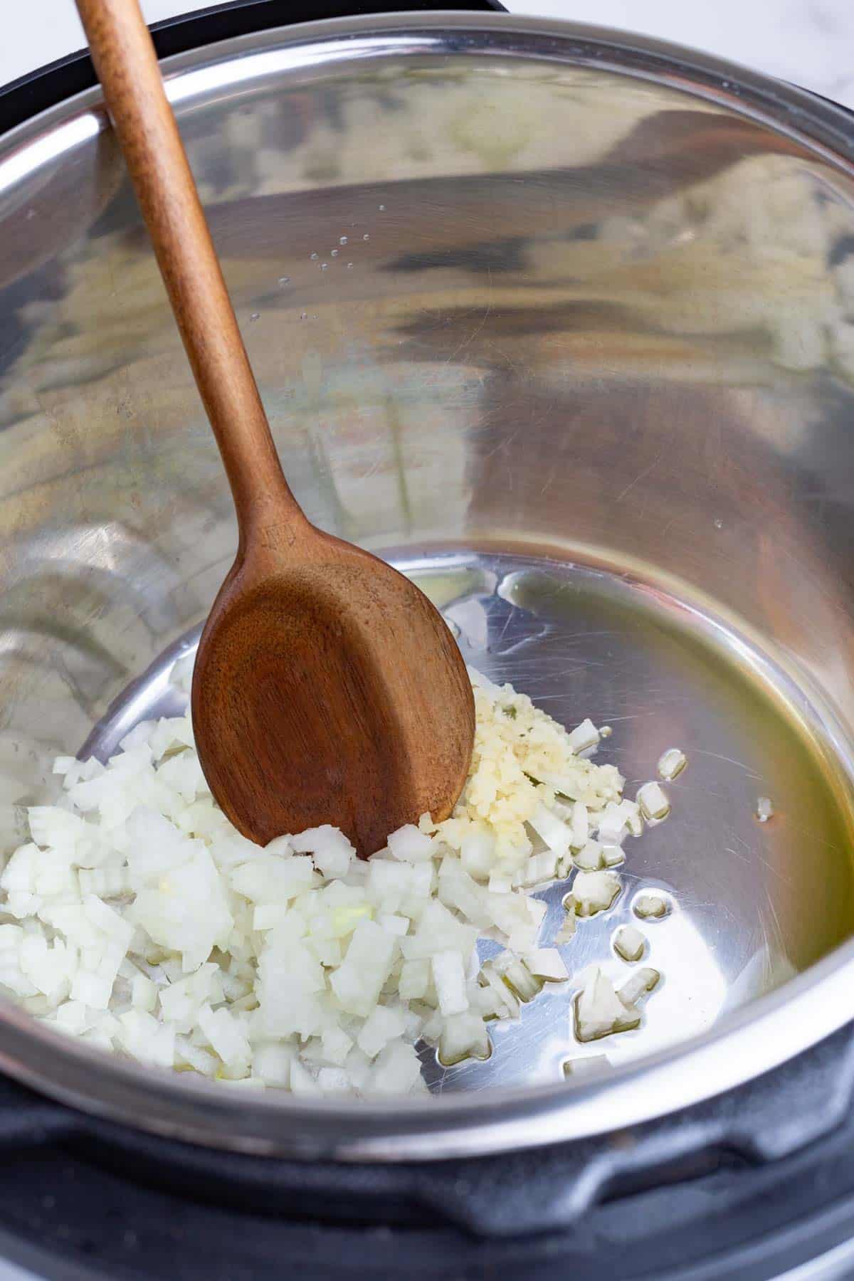Garlic is added to the onion in the Instant Pot.