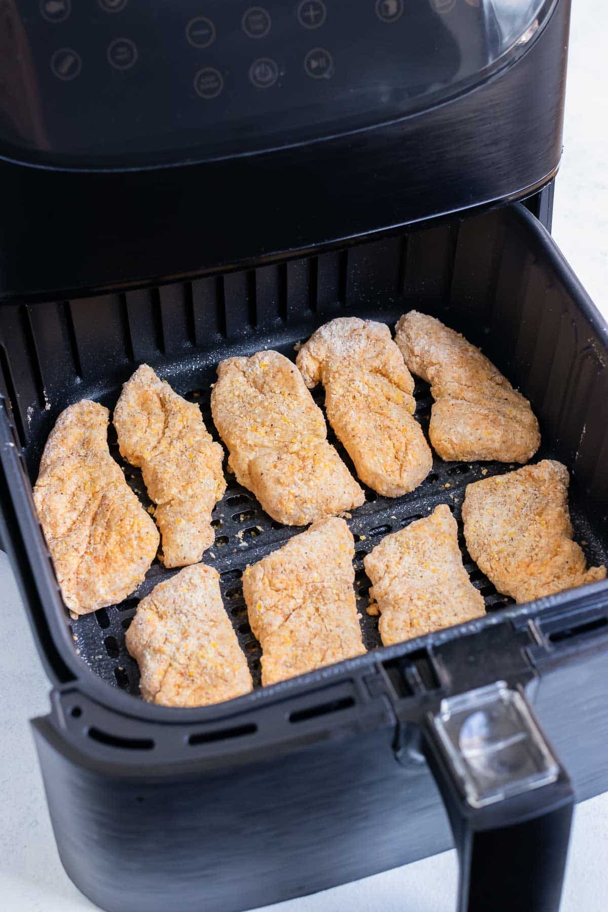 The coated fish is placed in the air fryer.