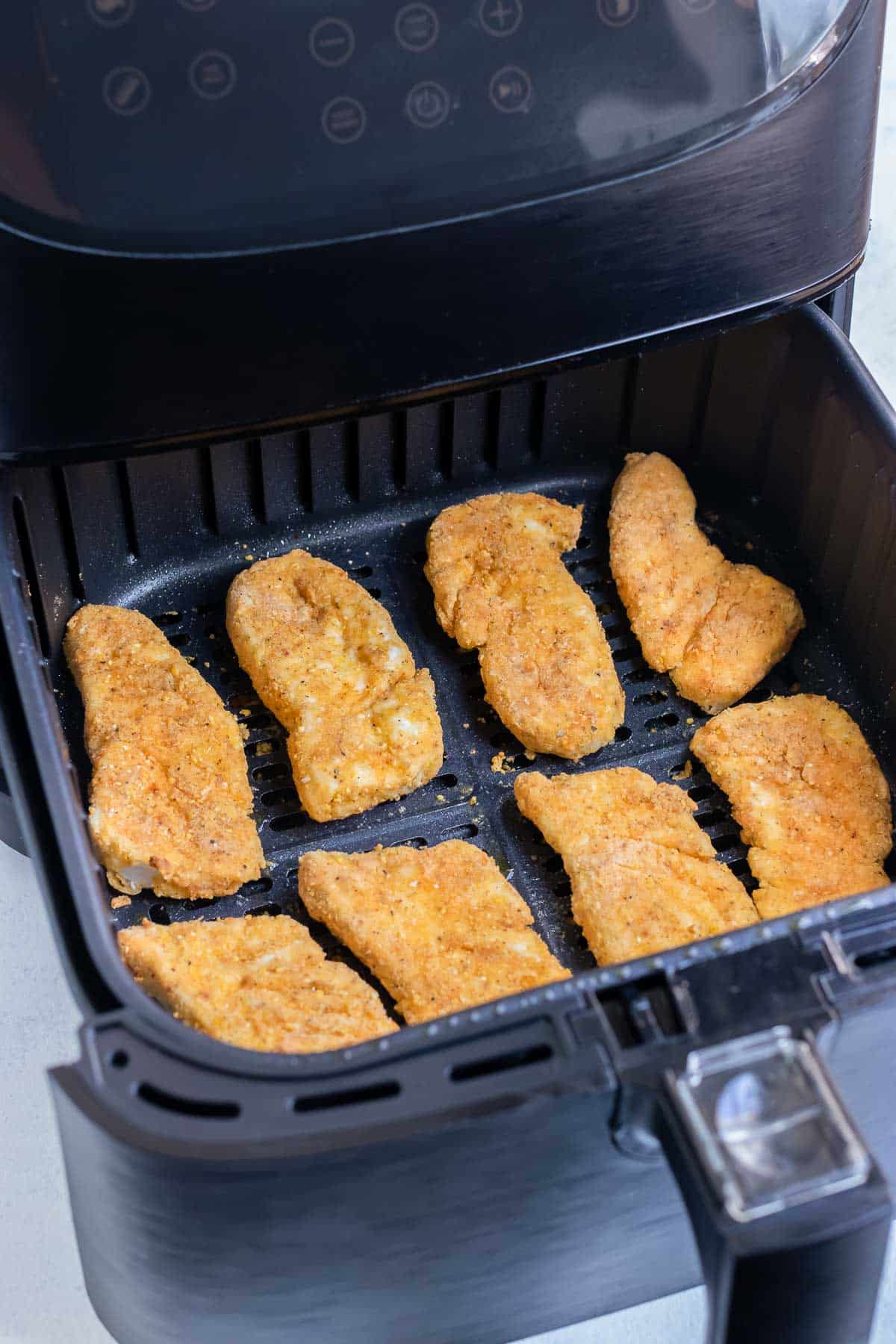 The fish is cooked in the air fryer until crispy.