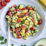 A bowl of avocado corn salad is served on the counter for a side dish.