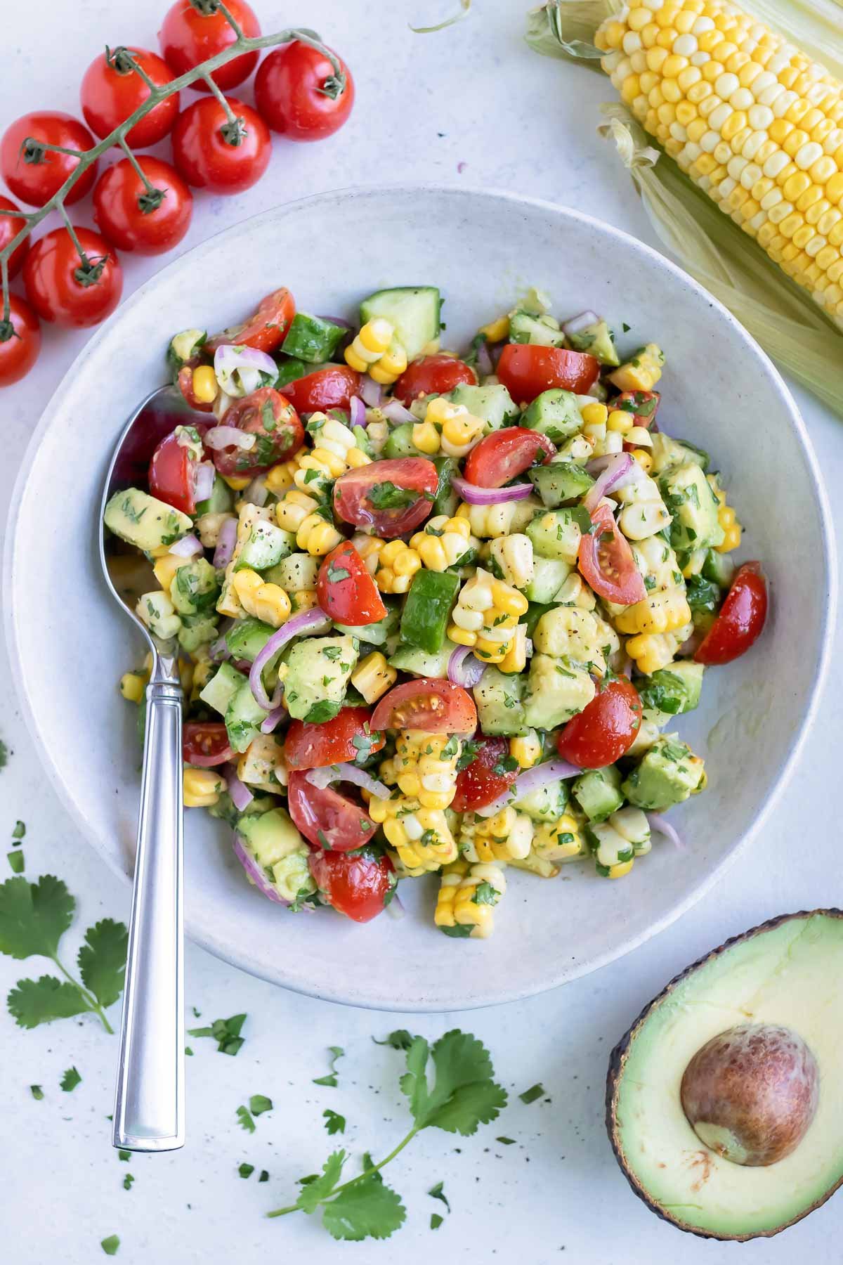 A bowl of avocado corn salad is served on the counter for a side dish.