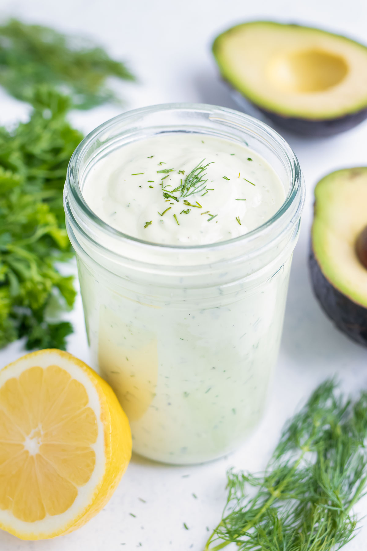 A mason jar is filled with homemade Avocado Ranch Dressing.