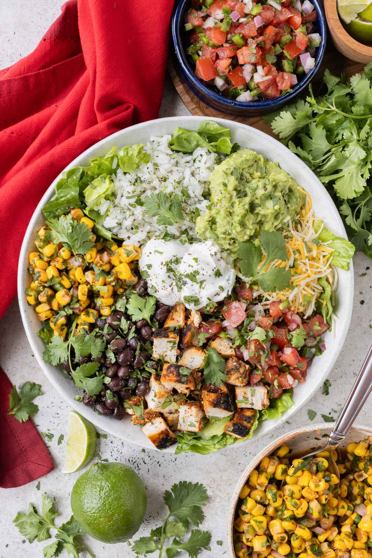 A Chipotle Burrito Bowl copycat recipe that was made at home with chipotle chicken, corn salsa, fresh tomato salsa, and cilantro lime rice.