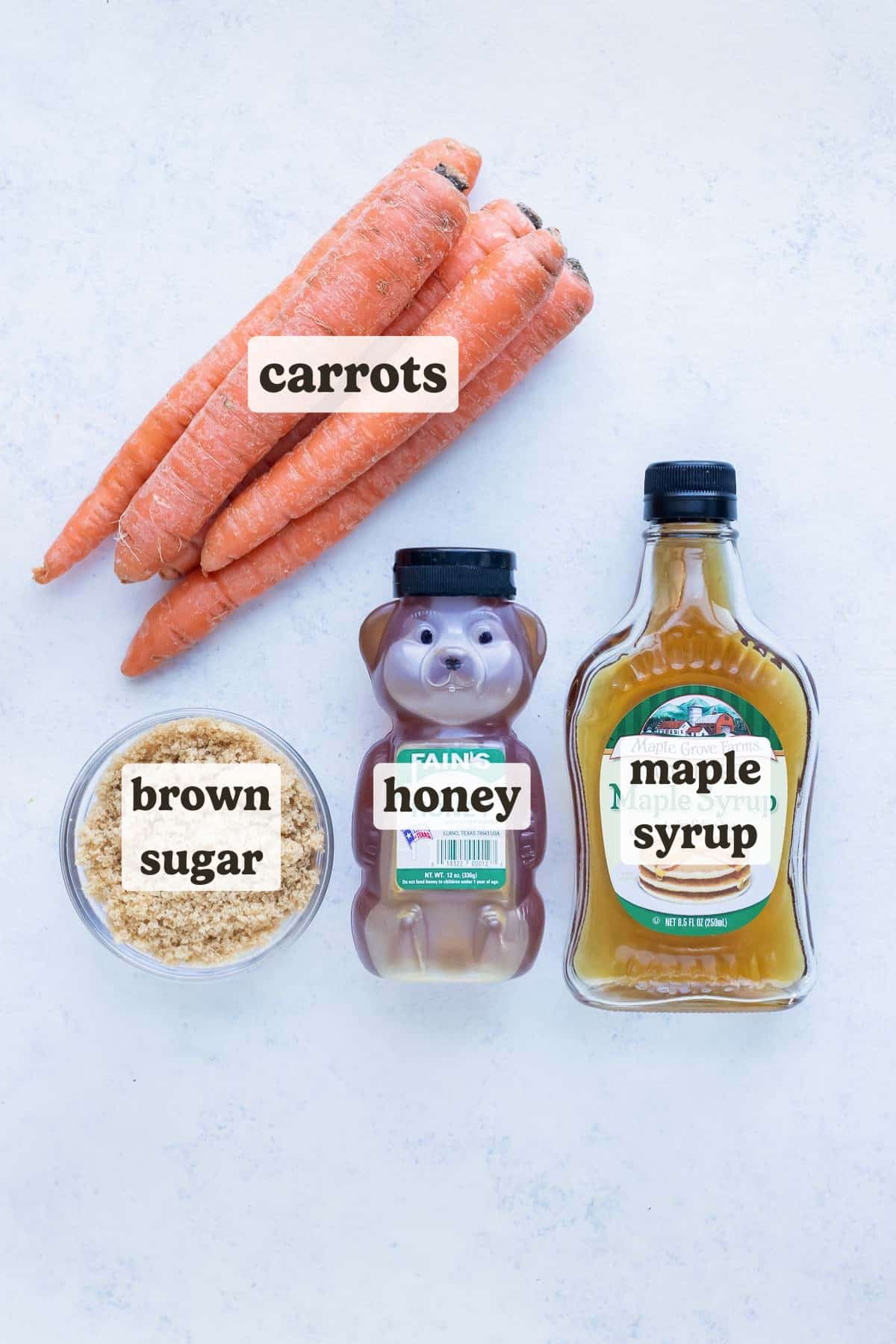 Carrots, honey, brown sugar, and maple syrup are shown for this boiled carrots recipe.