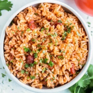 A white bowl is full of Instant Pot Mexican Rice made with salsa, white rice, and cilantro.