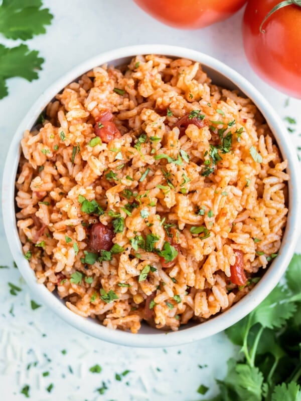 A white bowl is full of Instant Pot Mexican Rice made with salsa, white rice, and cilantro.